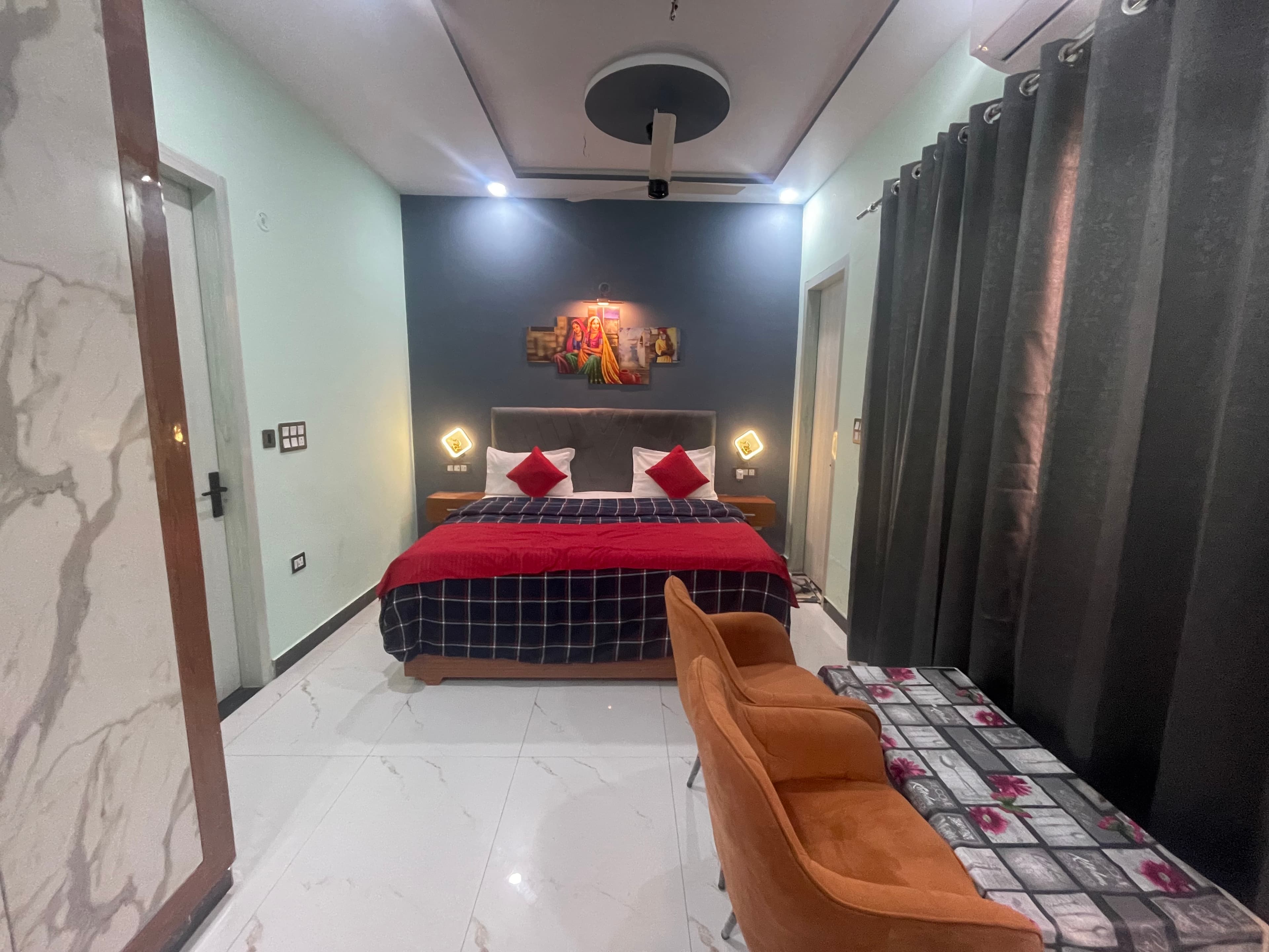 Wide-angle view of Deluxe room with marble floor, orange chairs and art panels