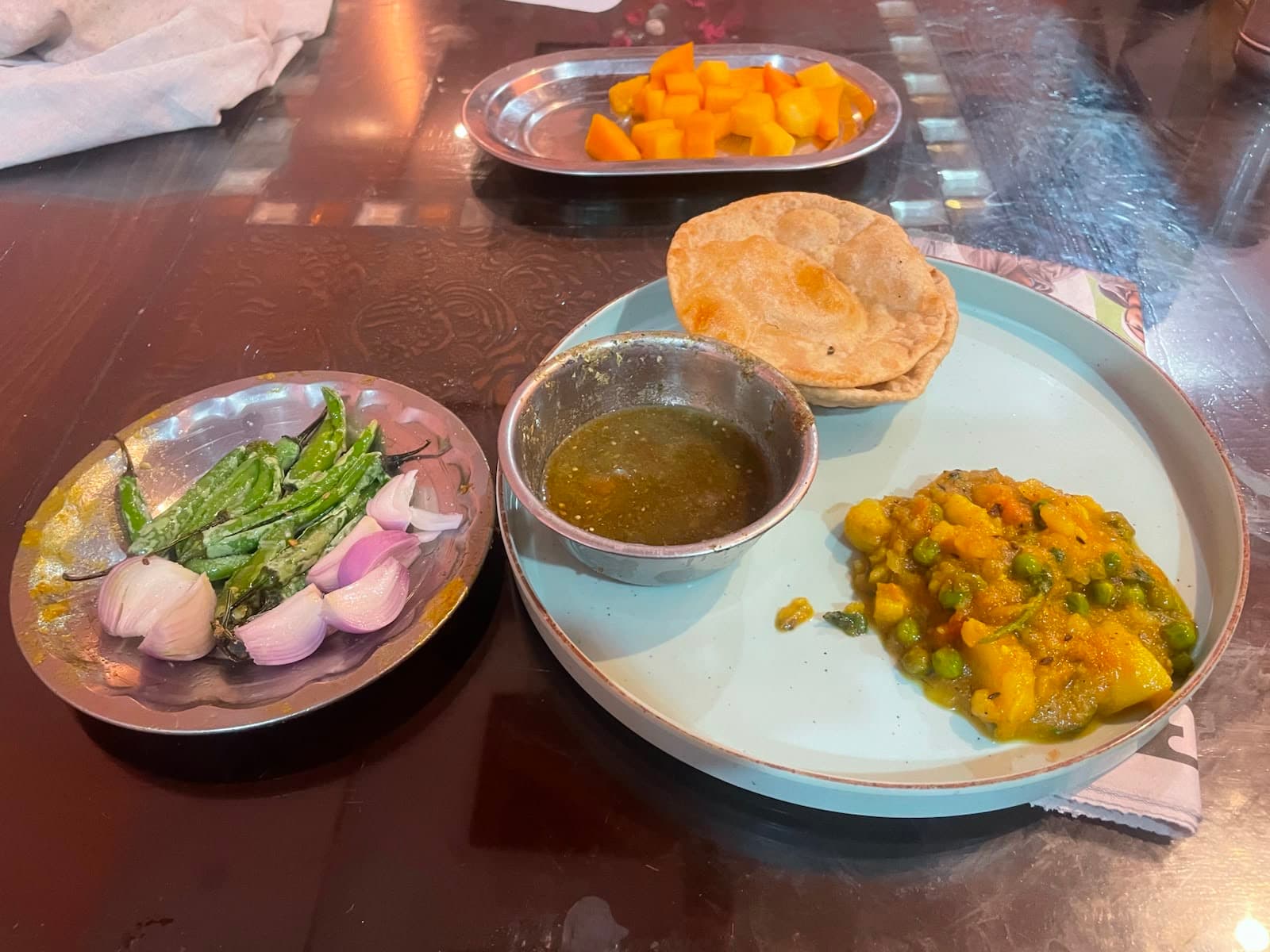 Home-cooked Indian breakfast โ puri, aloo sabzi, green chutney and fresh mango